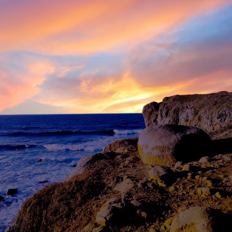 Rocky coastline at sunset with pink sky