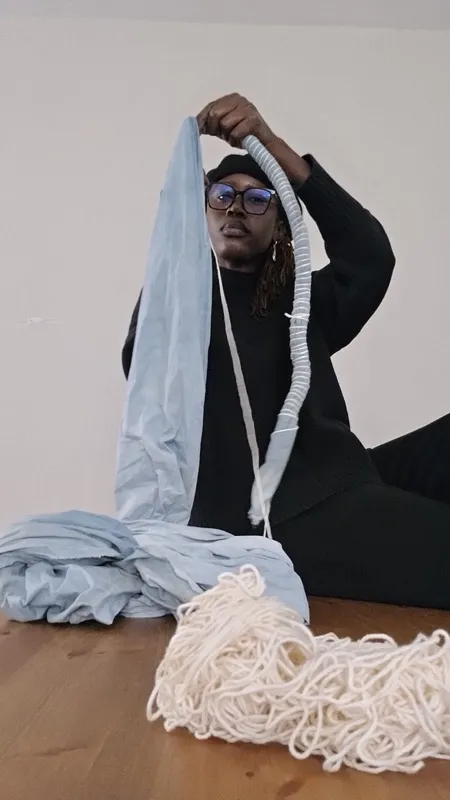 Diama wrapping yarn around blue fabric